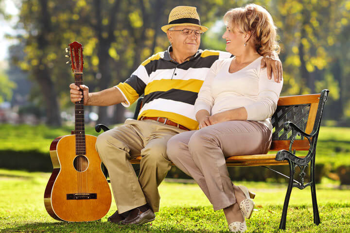 Husband and wife enjoying a sunny day in park