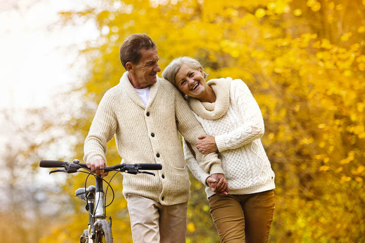 Active seniors walking with bike